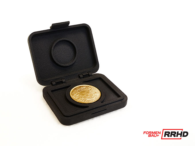 Eine glänzende Münze präsentiert in einer maßgeschneiderten, 3D-gedruckten schwarzen Box.