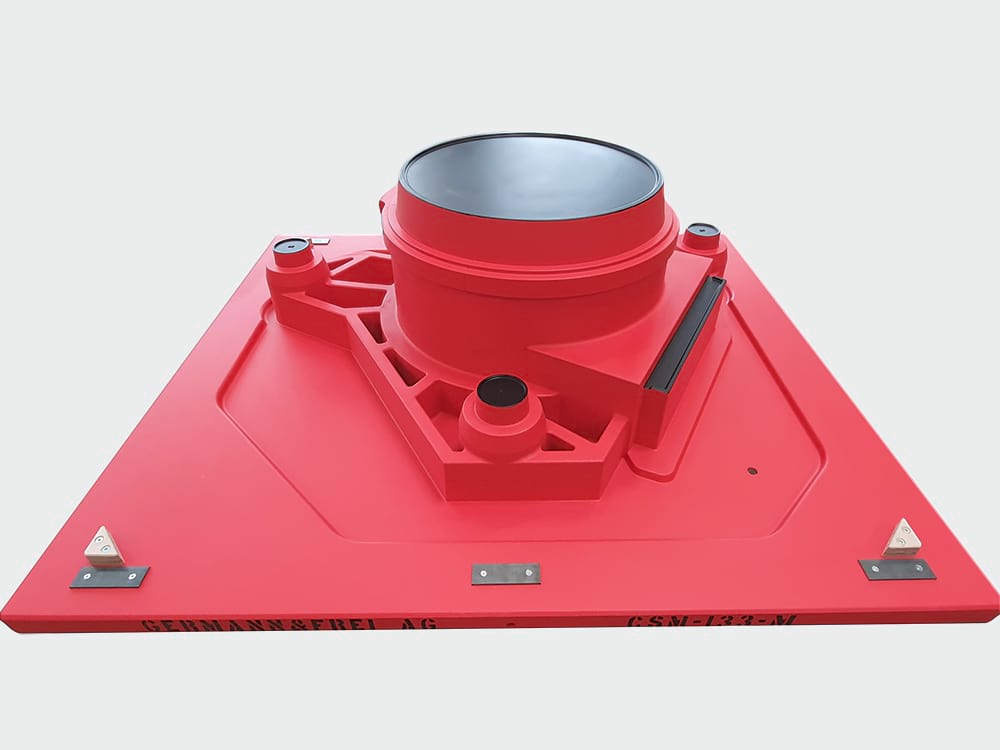 Rotes Gießereimodell mit zentralem zylindrischen Aufsatz auf einer großen, rechteckigen Grundplatte mit abgeschrägten Ecken. Das Modell verfügt über präzise Bearbeitungen und strukturierte Verstrebungen zur Formstabilität.