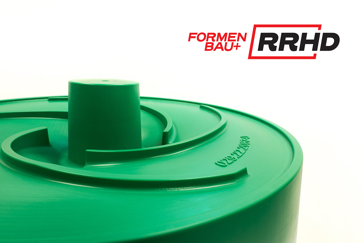 Grünes Gießereimodell mit spiralförmiger Geometrie und zylindrischem Mittelteil, aus Kunststoff gefertigt. Die Oberfläche ist glatt und trägt eine eingeprägte Beschriftung. Das Bauteil ist rotationssymmetrisch aufgebaut und dient der Herstellung eines Laufrads.